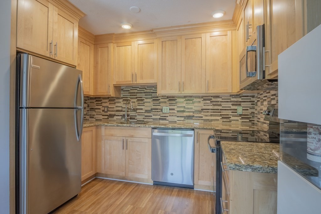 9 Barton Square, Unit 201 Salem, MA 01970 - Photo 15 of 42 a kitchen with stainless steel appliances granite countertop a refrigerator sink and cabinets