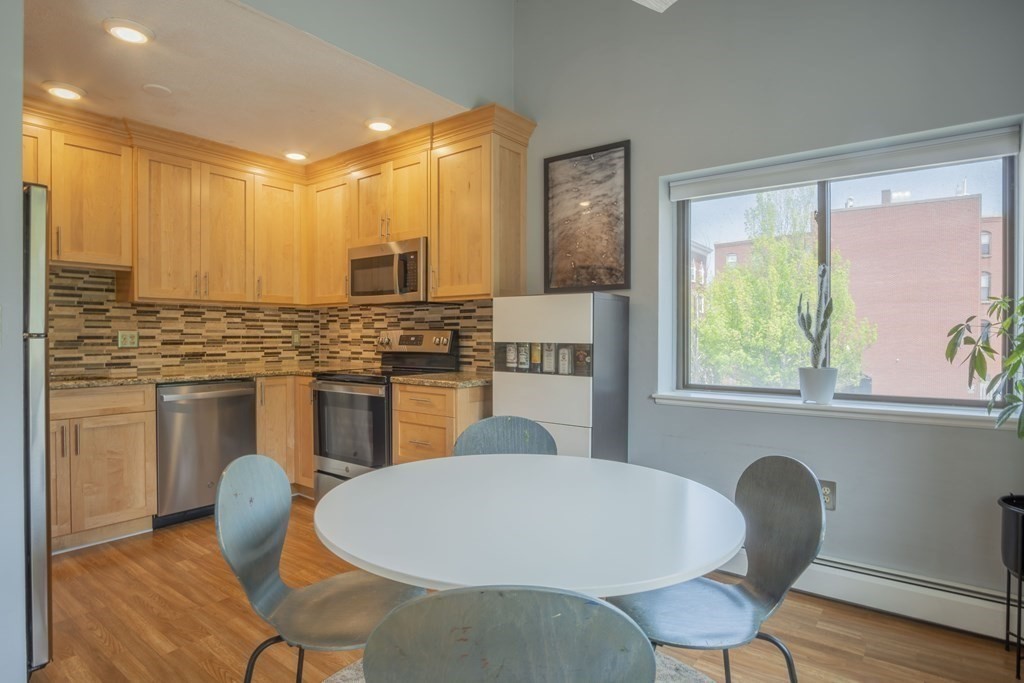 9 Barton Square, Unit 201 Salem, MA 01970 - Photo 17 of 42 a kitchen with a table chairs sink and cabinets