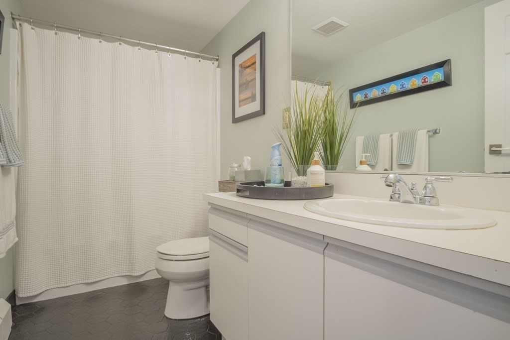 9 Barton Square, Unit 201 Salem, MA 01970 - Photo 24 of 42 a bathroom with a granite countertop sink a toilet and a mirror