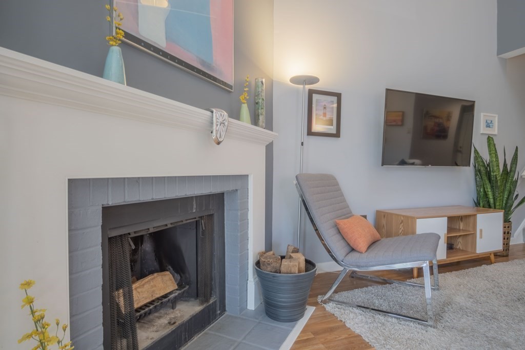 9 Barton Square, Unit 201 Salem, MA 01970 - Photo 10 of 42 a living room with furniture a flat screen tv and a fireplace