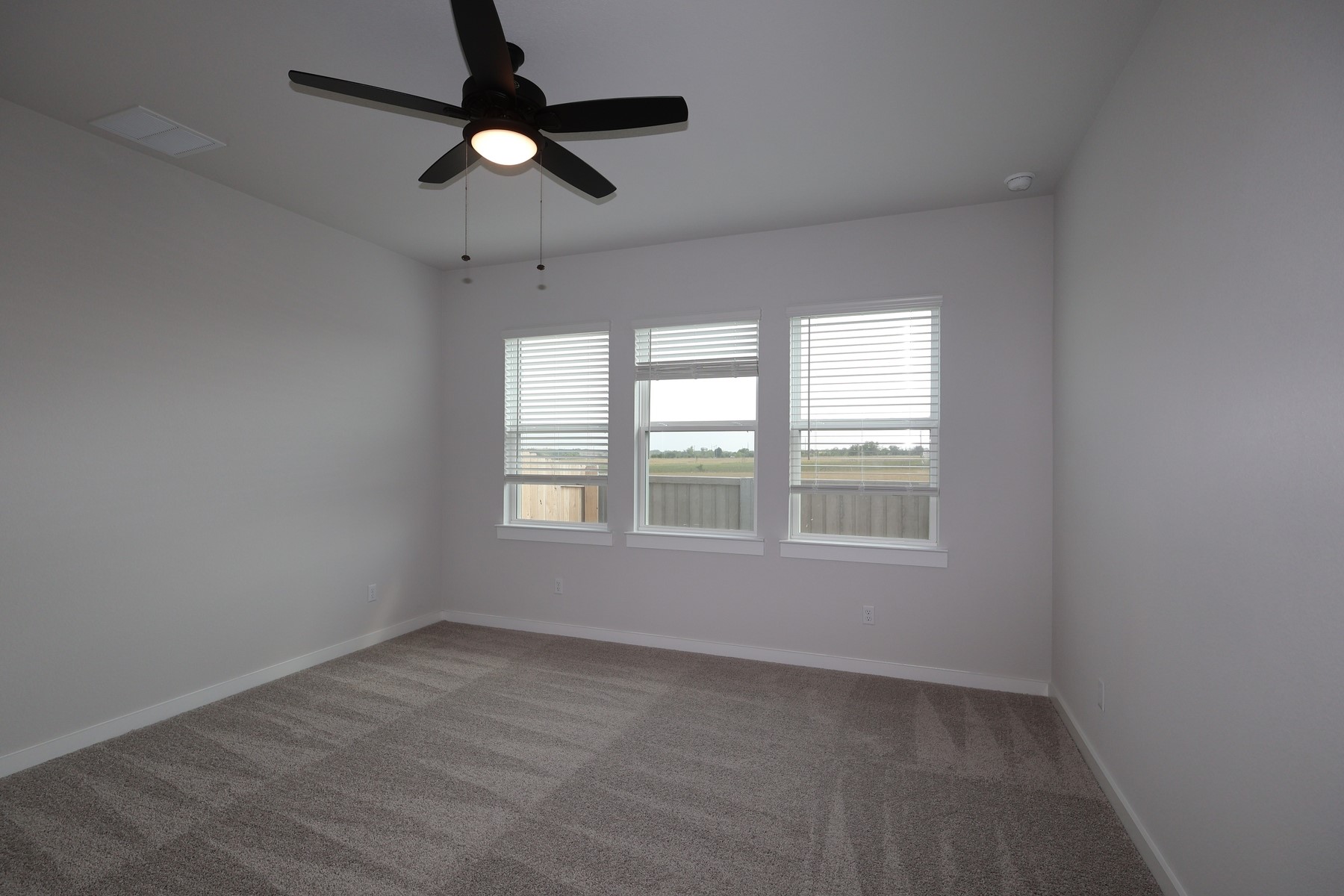 304 Emerie Way Georgetown, TX 78626 - Photo 6 of 15 an empty room with ceiling fan and windows
