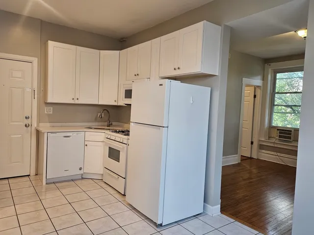 a kitchen with white cabinets and white appliances