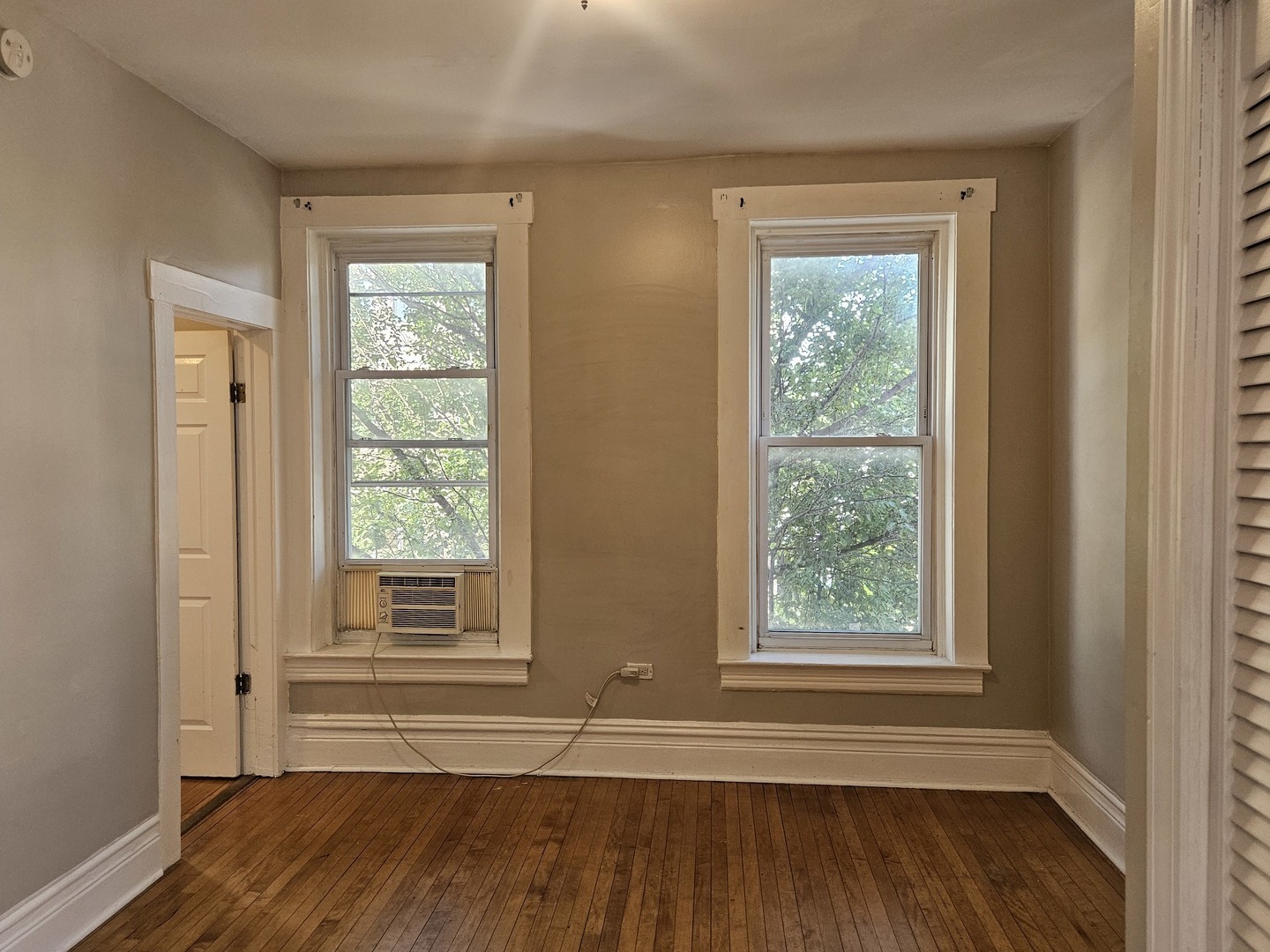 1025 West Cullerton Street, Unit 2F Chicago, IL 60608 - Photo 7 of 15 a view of an empty room with wooden floor and a window