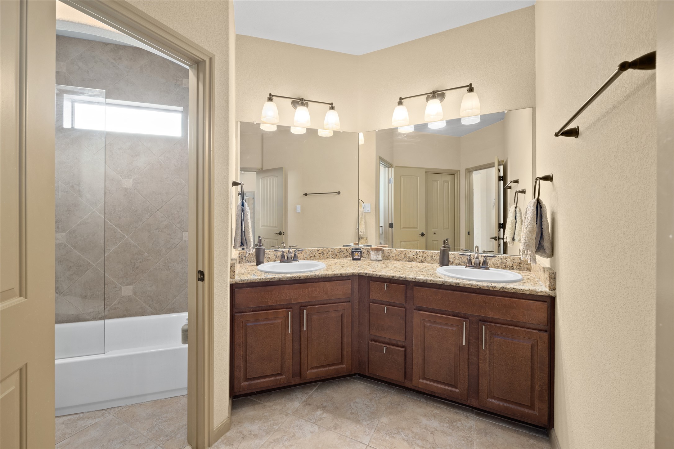1690 Hickory Creek Road Marble Falls, TX 78654 - Photo 11 of 25 Full bath with double vanity, shower / bathtub combination, and light tile patterned flooring