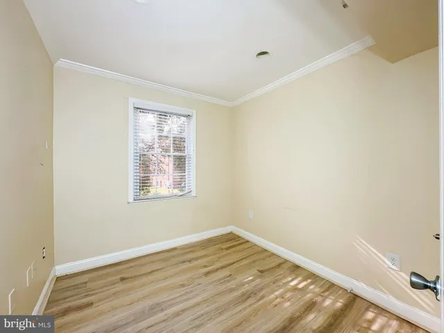 a view of a room that has wooden floor and bench in it