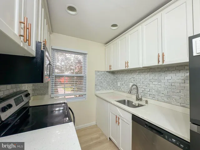 a kitchen with a sink a stove and cabinets