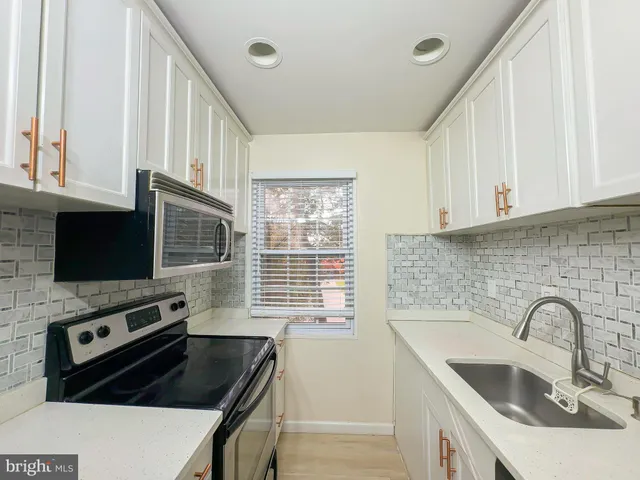 a kitchen with stainless steel appliances a stove a sink a microwave and cabinets