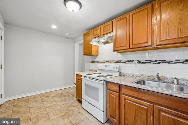 a kitchen with stainless steel appliances granite countertop a sink and a stove