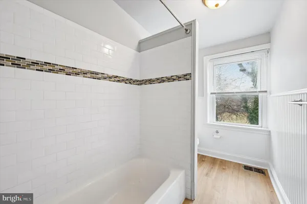 a bathroom with a window a bathtub and a shower