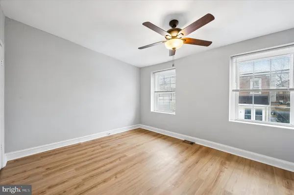 a view of wooden floor and a chandelier fan in a room