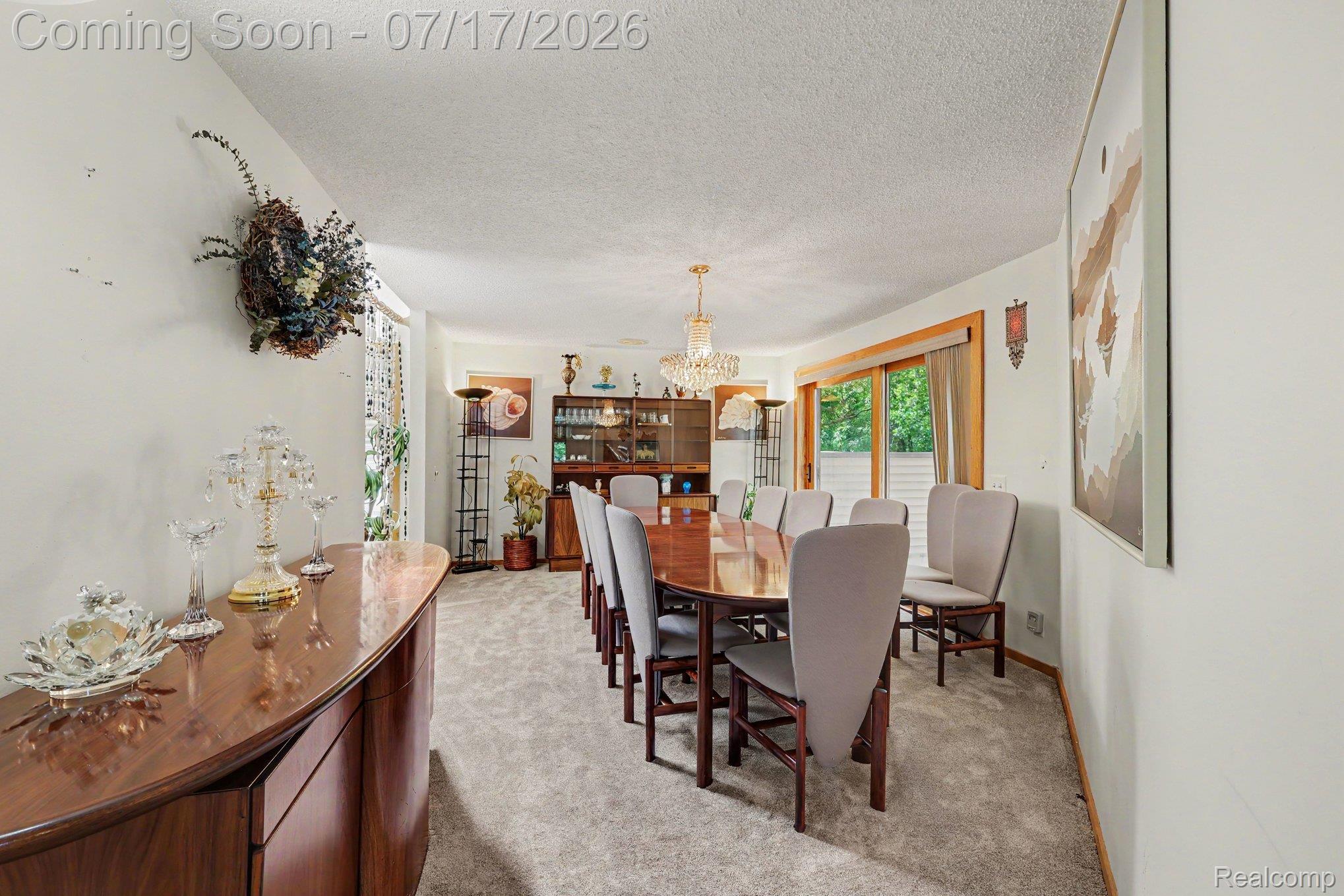 5685 Paint Valley Drive Rochester, MI 48306 - Photo 15 of 66 Spacious dining area featuring neutral carpeting, a large wood-finish dining table, and a crystal chandelier