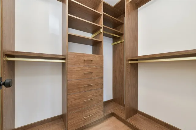 a view of walk in closet with empty racks