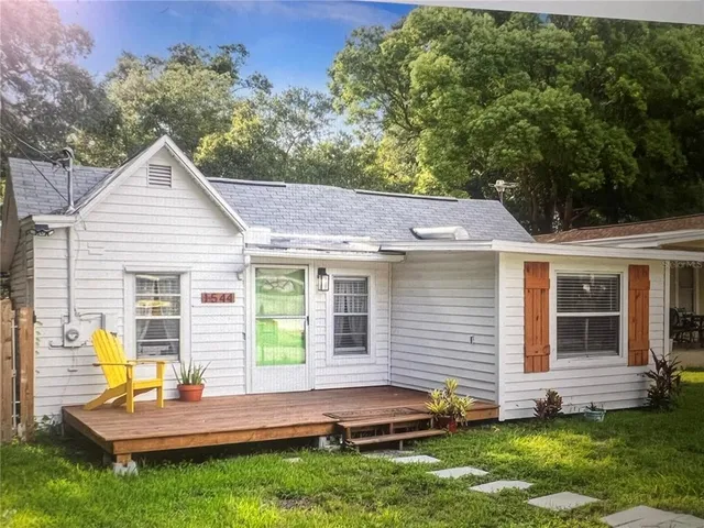 a backyard of a house with table and chairs
