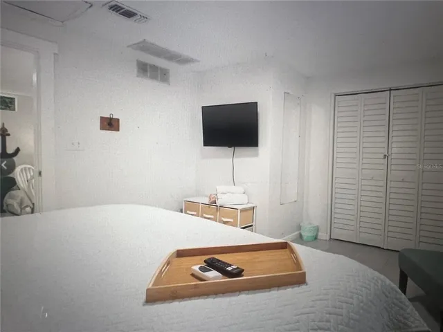 a bedroom with a bed and a flat screen tv