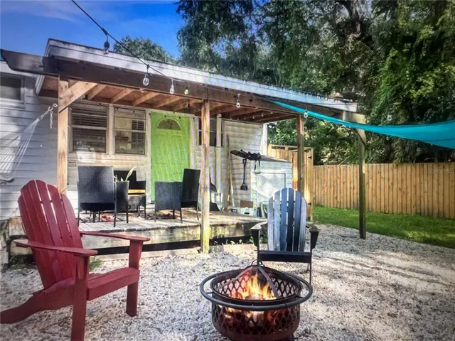 a backyard of a house with yard fire pit table and chairs