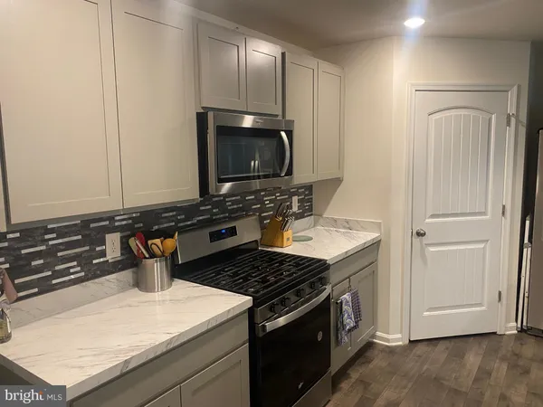 a kitchen with stainless steel appliances granite countertop a stove and a microwave