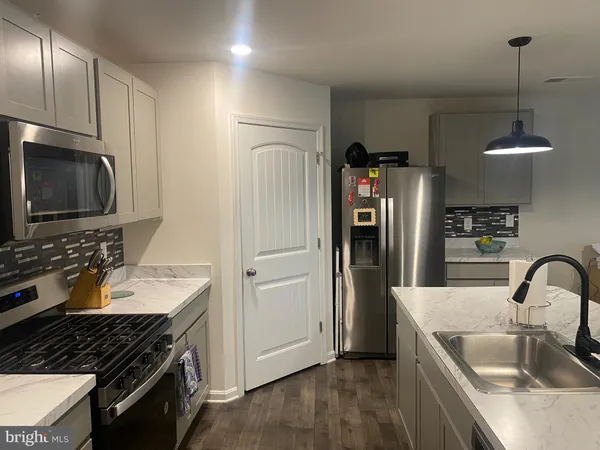a kitchen with granite countertop a refrigerator and a sink