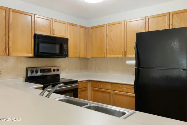 a kitchen with a refrigerator a stove a microwave and cabinets