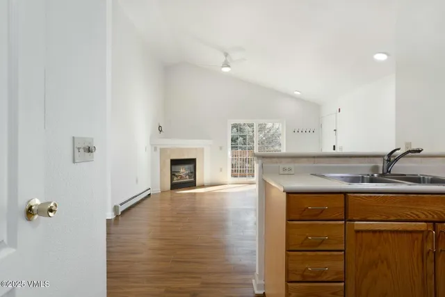 a view of a kitchen with a sink a fireplace and window