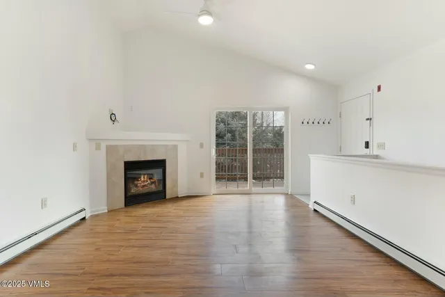 an empty room with wooden floor and a fireplace