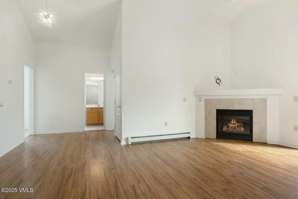 a view of a room with wooden floor and a fireplace
