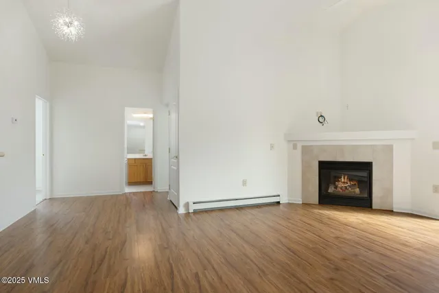 a view of a room with wooden floor and a fireplace