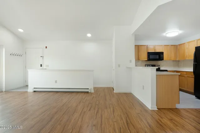 a view of kitchen with wooden floor and electronic appliances