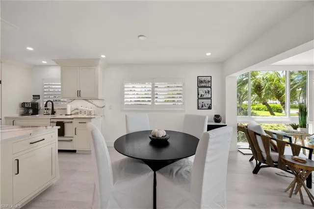 a kitchen with stainless steel appliances a table chairs and a refrigerator