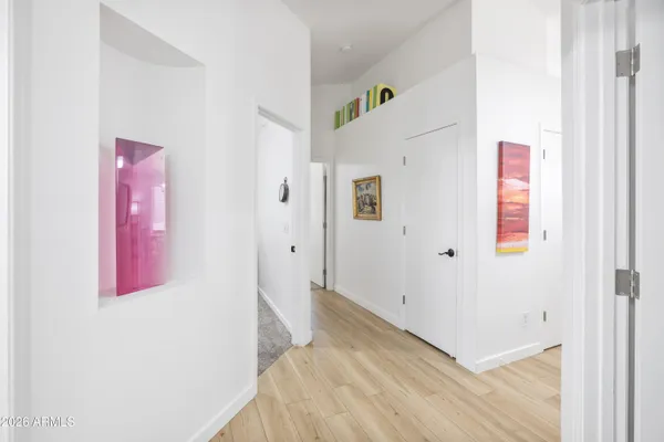 a living room with baby crib and a wooden floor