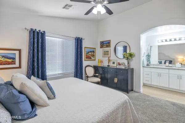 a bedroom with a large bed and a chandelier