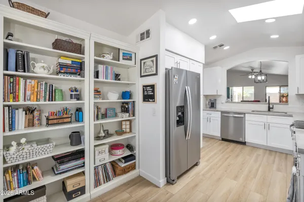 a kitchen with stainless steel appliances cabinets and a wooden floor
