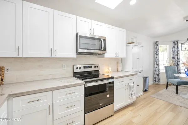 a kitchen with stainless steel appliances granite countertop a refrigerator and a stove top oven