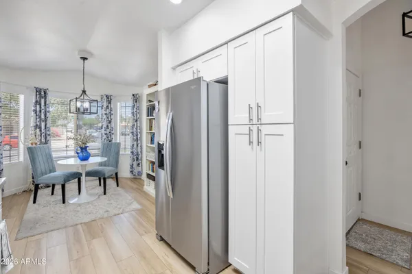 a living room with furniture a dining table and paintings on the wall