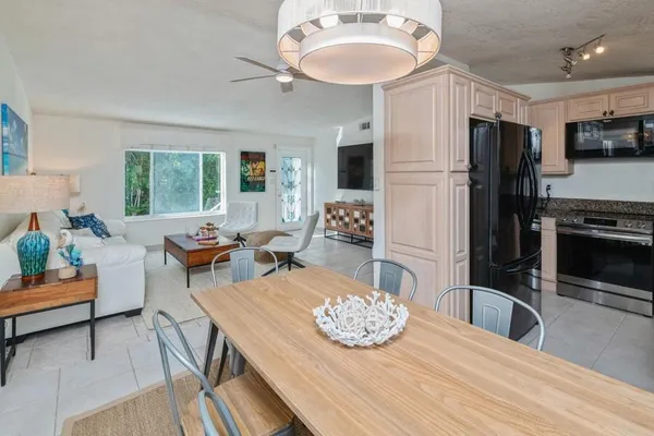 a view of a dining room with furniture a kitchen and chandelier