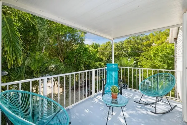 a balcony with chairs and wooden floor