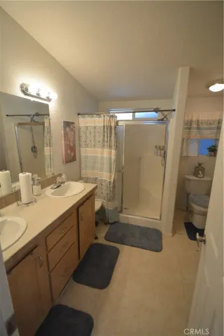 a bathroom with a double vanity sink toilet and shower