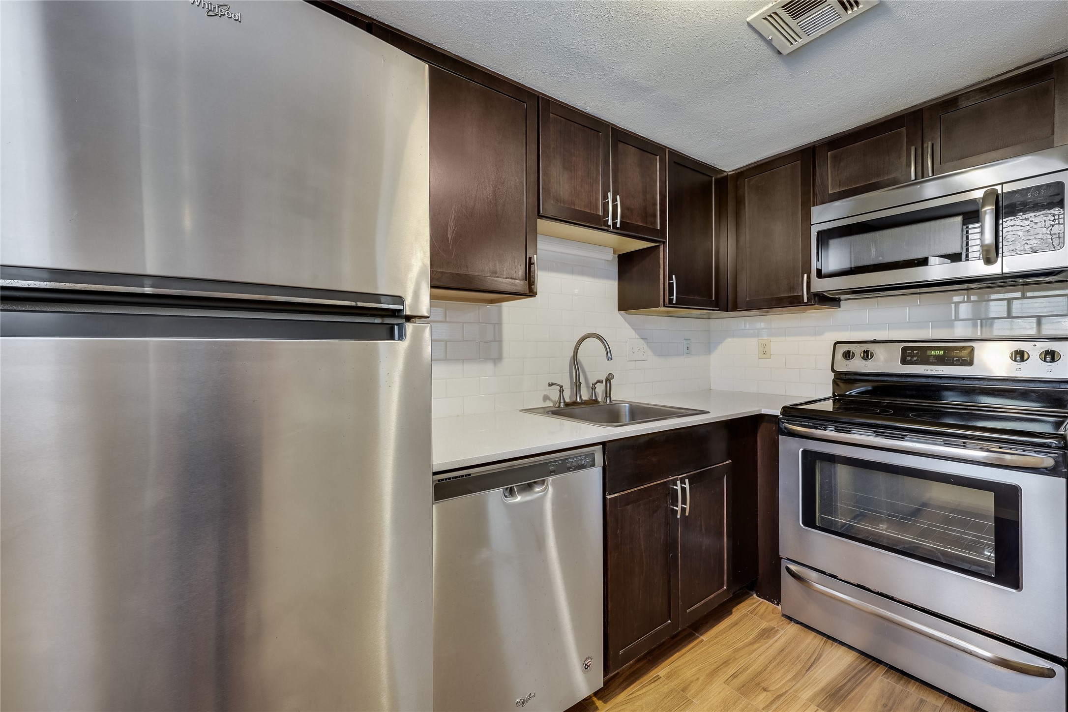 2500 Burleson Road, Unit 609 Austin, TX 78741 - Photo 18 of 32 A streamlined kitchen showcasing stainless steel appliances and classic subway tile backsplash.