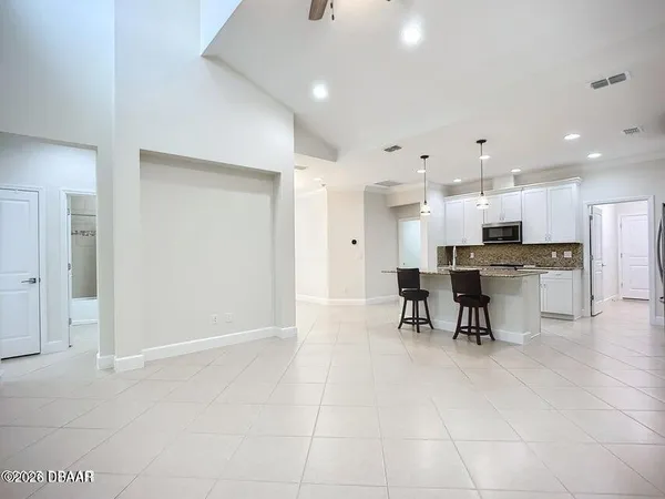 a view of an empty room with a kitchen
