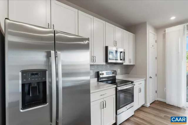 a kitchen with stainless steel appliances a sink and a large window