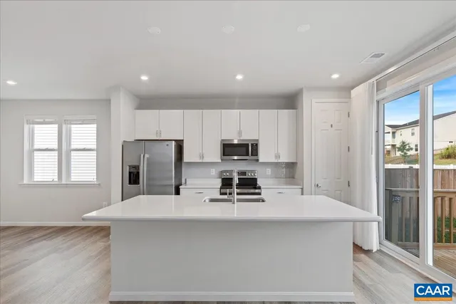 a kitchen with kitchen island a sink stainless steel appliances and cabinets