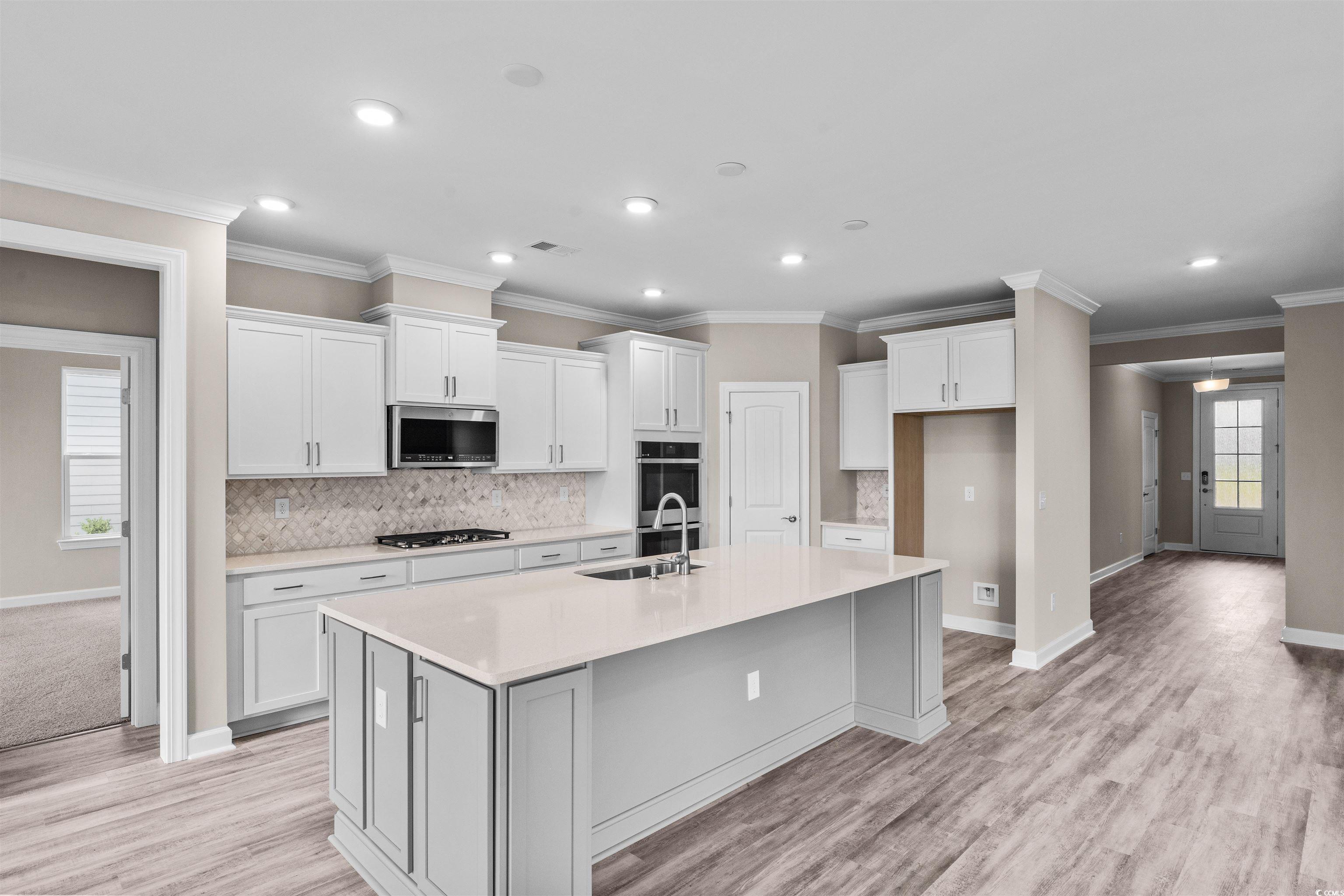 763 St Vincent Loop Little River, SC 29566 - Photo 9 of 33 Kitchen featuring appliances with stainless steel finishes, white cabinets, a spacious island, recessed lighting, and backsplash