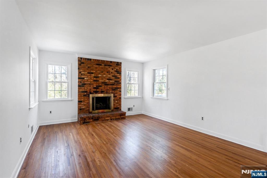 139 Berkeley Circle Bernards, NJ 07920 - Photo 13 of 36 an empty room with windows a fireplace and wooden floor