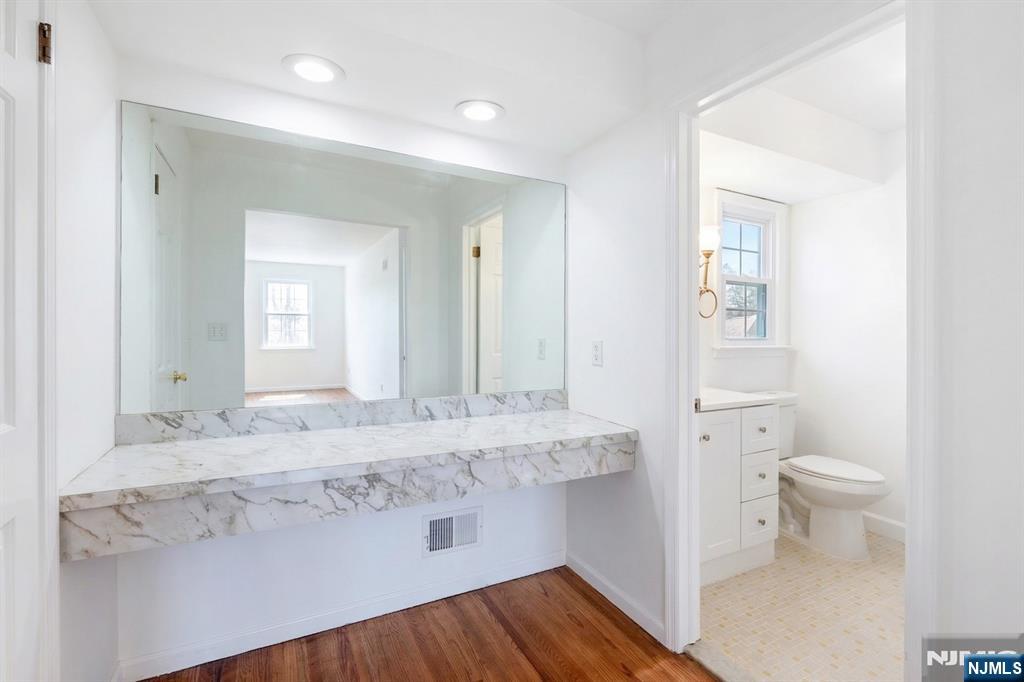 139 Berkeley Circle Bernards, NJ 07920 - Photo 22 of 36 a bathroom with a granite countertop sink a toilet and a mirror