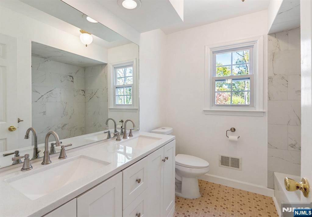 139 Berkeley Circle Bernards, NJ 07920 - Photo 23 of 36 a bathroom with a toilet a sink a mirror a window and vanity
