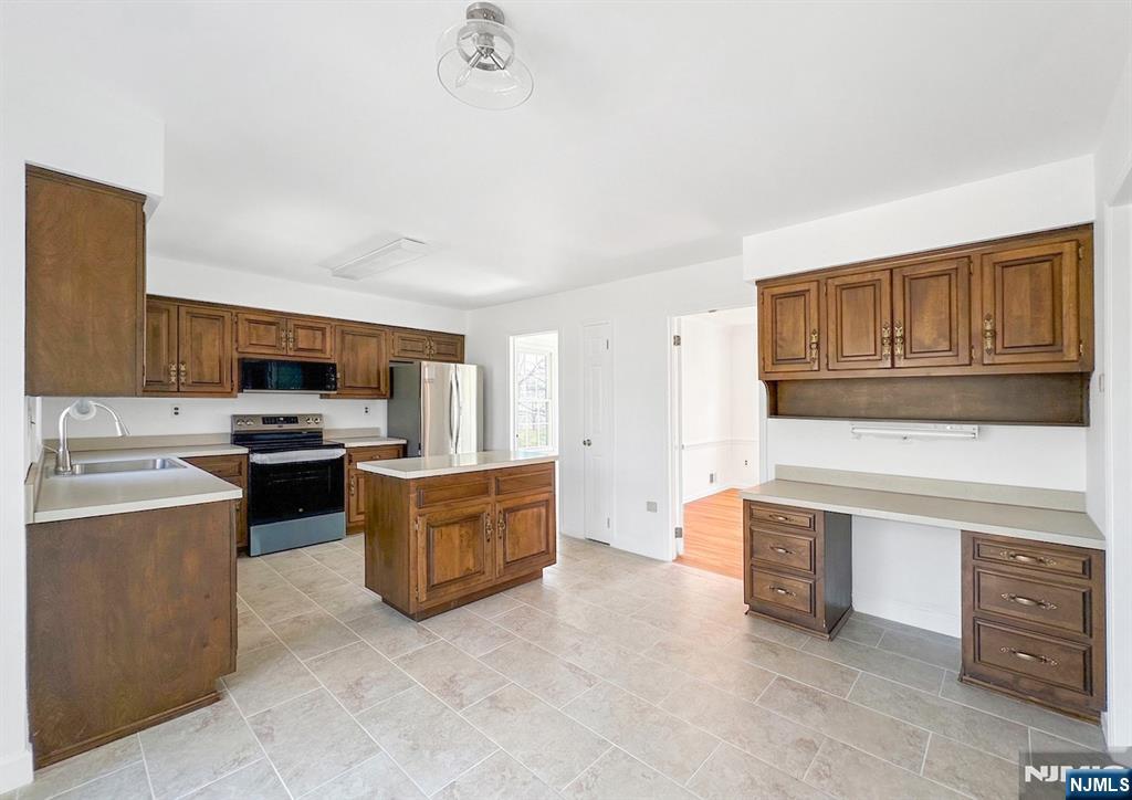 139 Berkeley Circle Bernards, NJ 07920 - Photo 6 of 36 a kitchen with stainless steel appliances granite countertop a stove top oven a sink dishwasher and a refrigerator with wooden cabinets