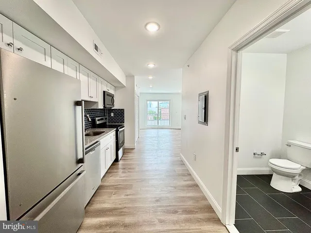 a kitchen with stainless steel appliances a refrigerator and a stove top oven