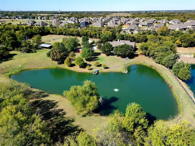 an aerial view of a house with a yard and lake view