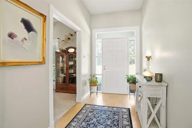 a hallway with wooden floor and a chandelier