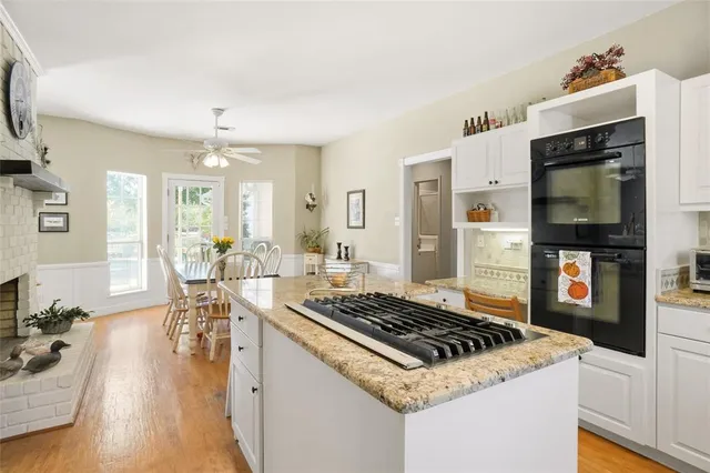 a kitchen with a stove and wooden floor