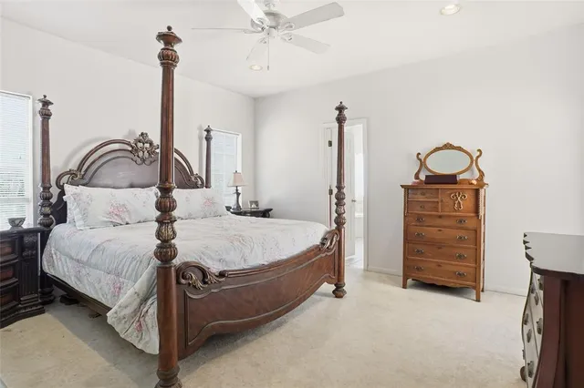 a bedroom with a bed a dresser and with potted plants